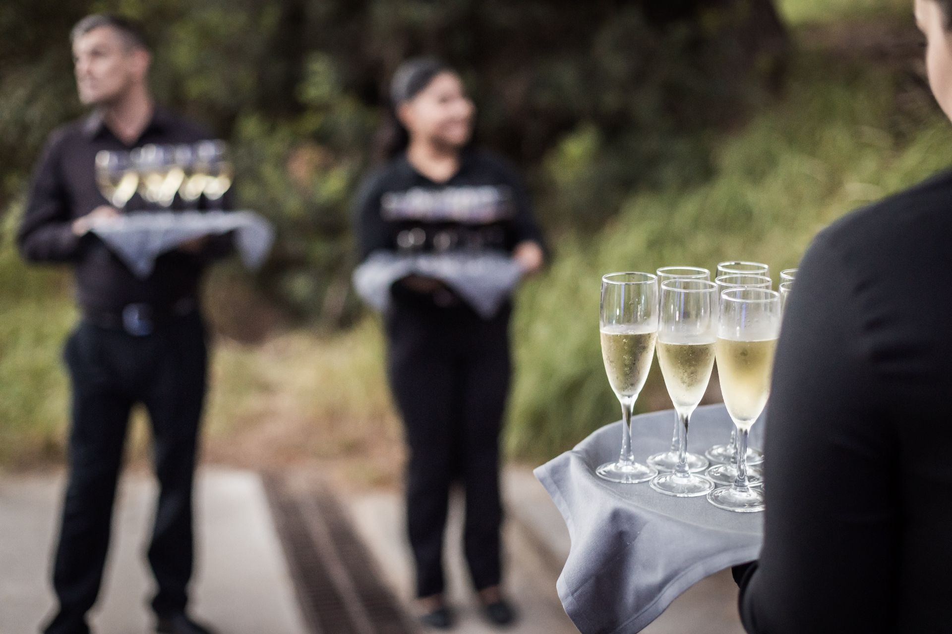 Camareros sirviendo copas de cava en los jardines