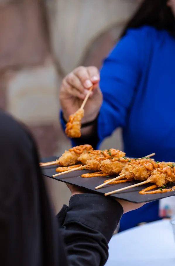 Brochetas crujientes con salsa servidas en pizarra