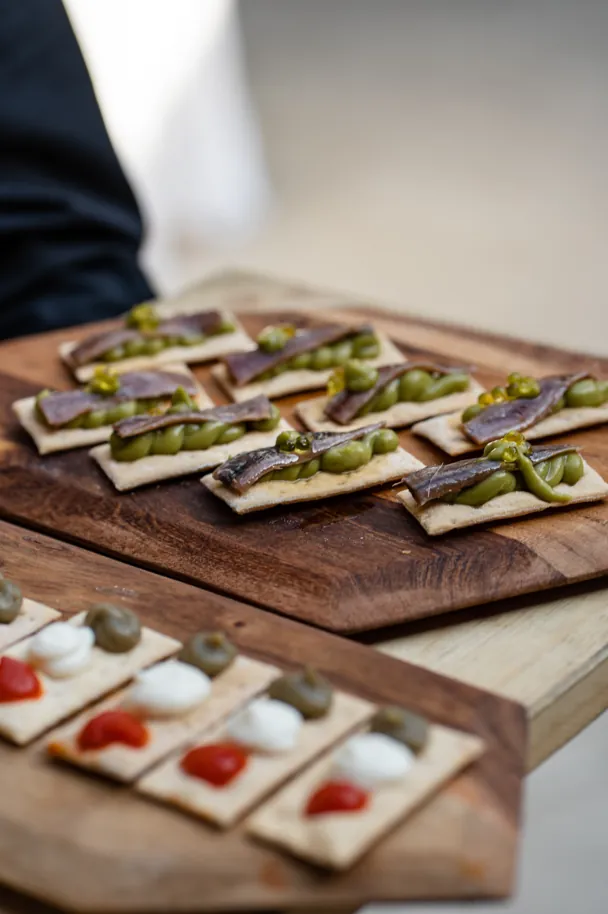 Canapés de anchoa y guacamole sobre tabla de madera