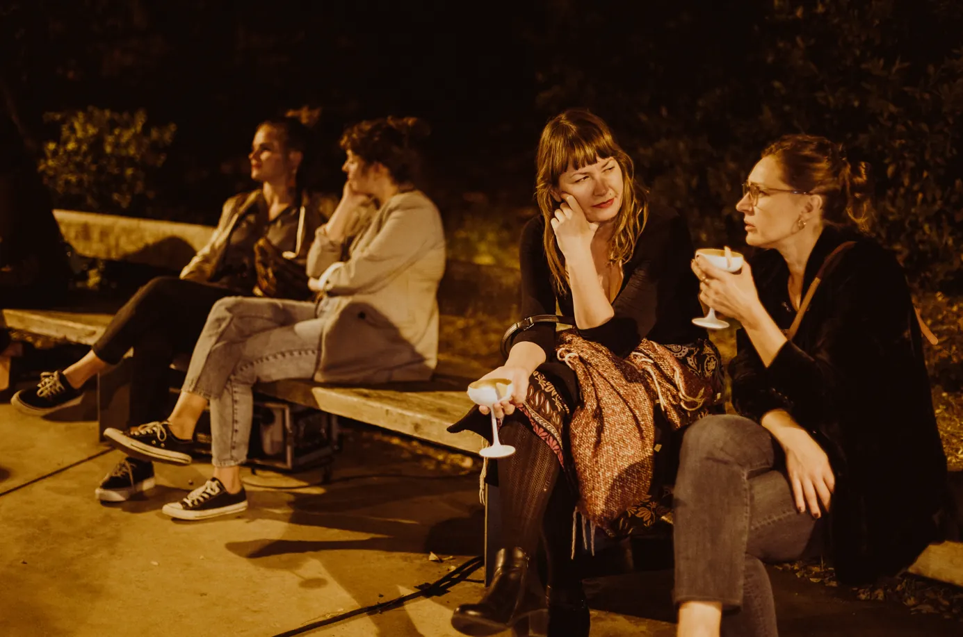 Invitadas conversando en el exterior durante un evento nocturno