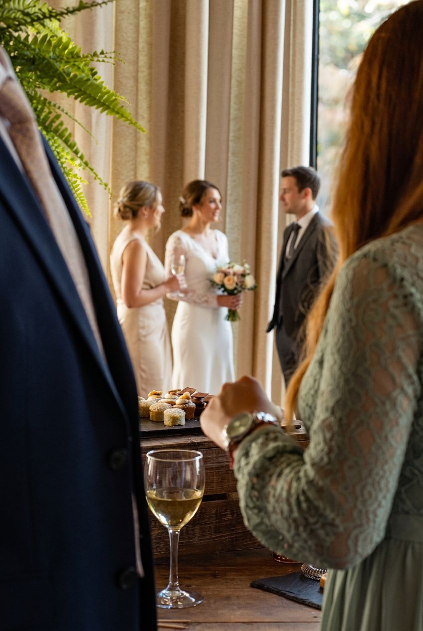 Novios y damas de honor junto a la mesa dulce